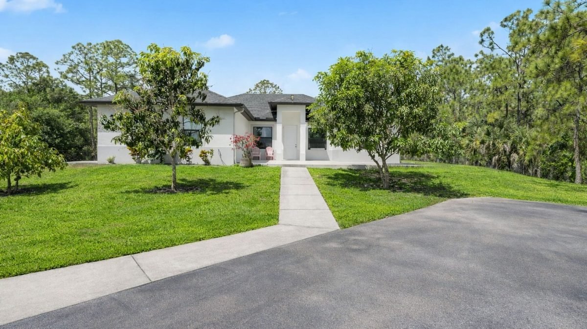 Single-story home with landscaped front yard and paver walkway in Naples, Florida