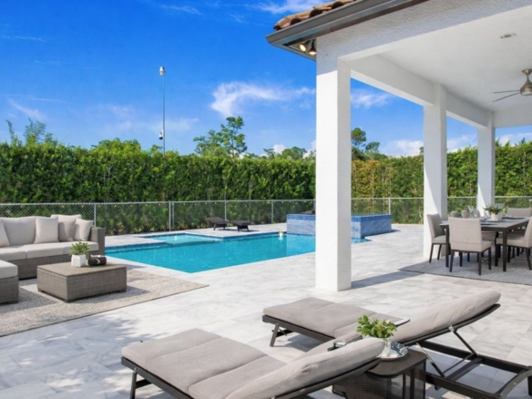 Private pool and covered lanai with lounge seating at 6341 Green Blvd, Golden Gate Estates, Naples FL