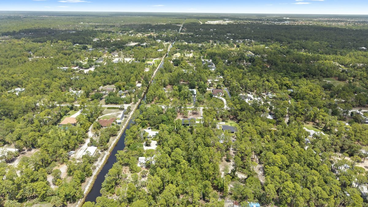 Aerial view of Golden Gate Estates in Naples, Florida, with wooded acreage lots and a canal