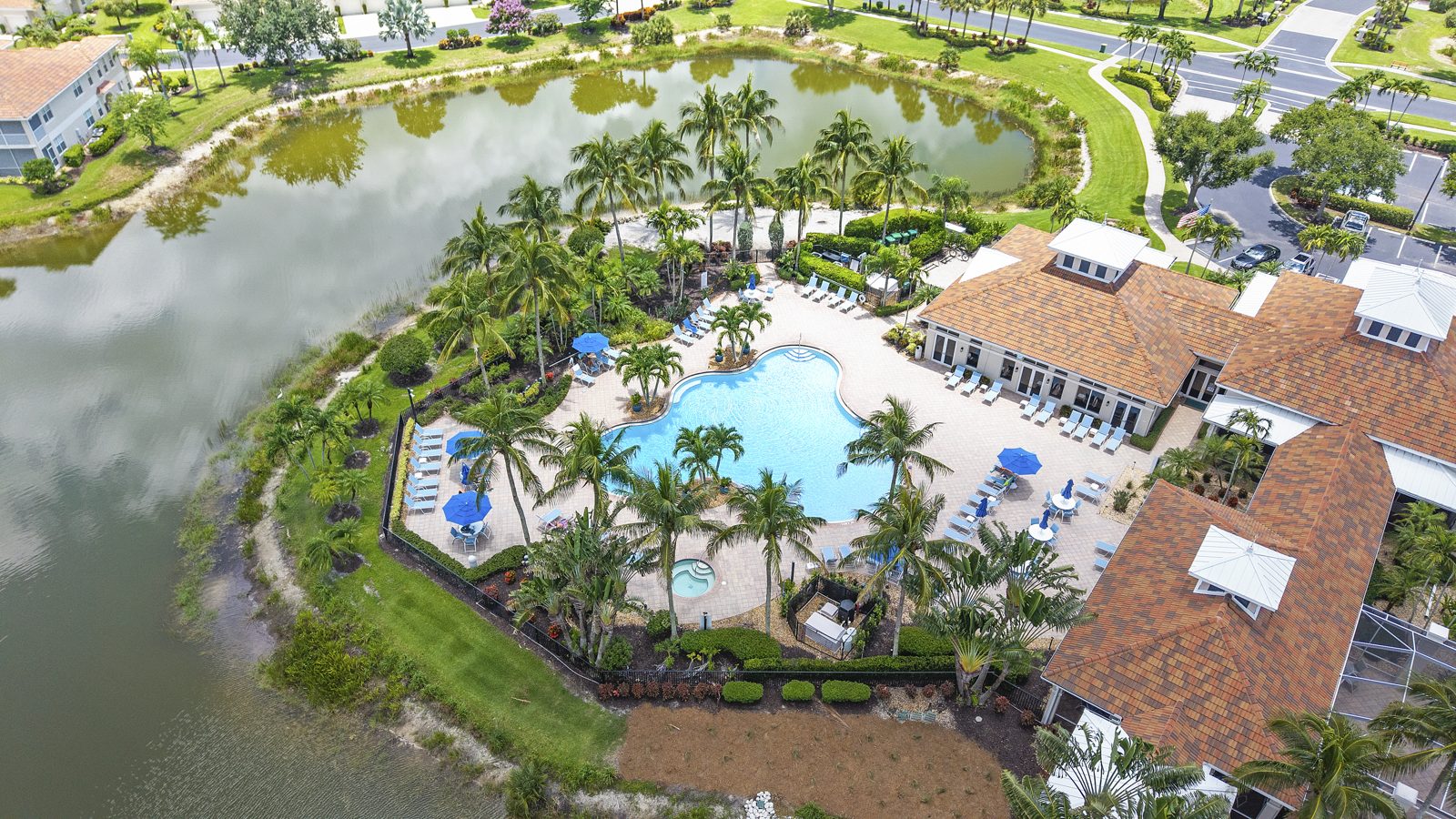 Aerial view of the lakeside resort-style pool and clubhouse at Bridgewater Bay in North Naples, Florida