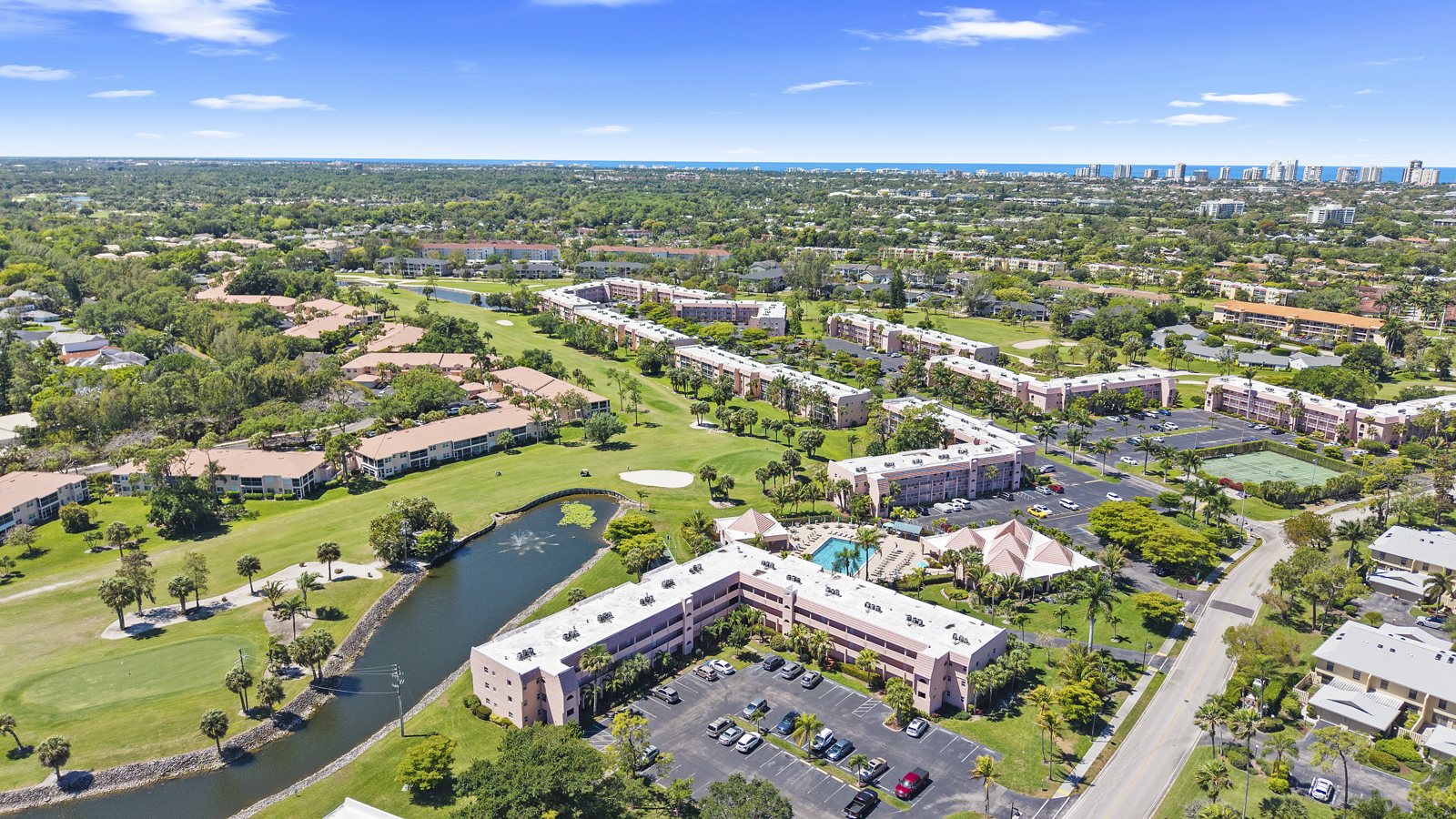 Aerial view of Forest Lakes Blvd condos and Quail Run golf course with the Naples coastline on the horizon