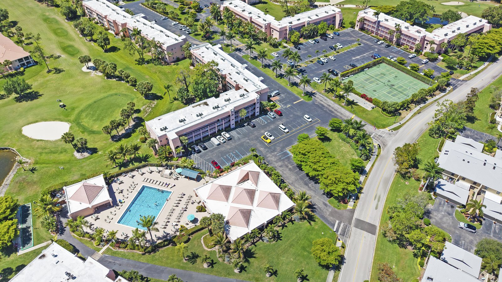 Aerial view of the pool, clubhouse, tennis courts and golf course at Turtle Lake Golf Colony on Forest Lakes Blvd, Naples FL