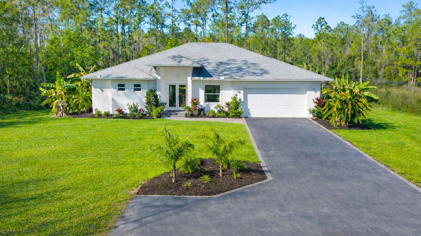 Single-family home with landscaped lawn and driveway in Naples, Florida — the kind of property owners want valued