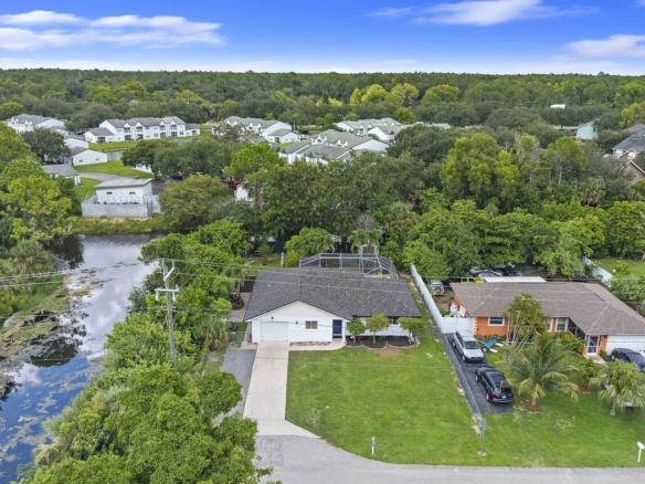 Aerial view of a canal-front pool home on a hammerhead lot in Golden Gate City, Naples, Florida — water on two sides