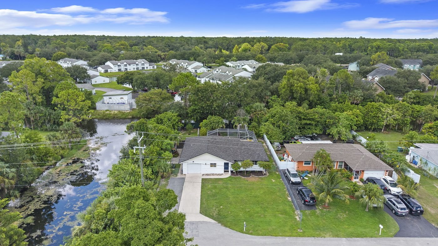 Aerial view of a canal-front pool home on a hammerhead lot in Golden Gate City, Naples, Florida — water on two sides