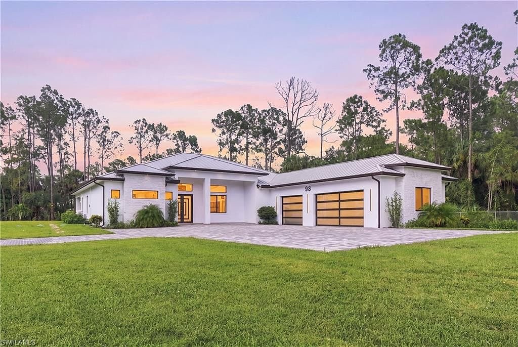 Twilight front exterior of 98 10th St NE, new construction estate on 2.81 acres in Golden Gate Estates, Naples FL