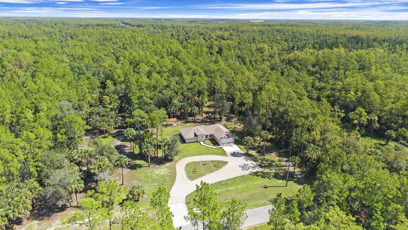 Aerial of a Golden Gate Estates home on a selectively cleared building envelope surrounded by native pine forest in Naples, Florida