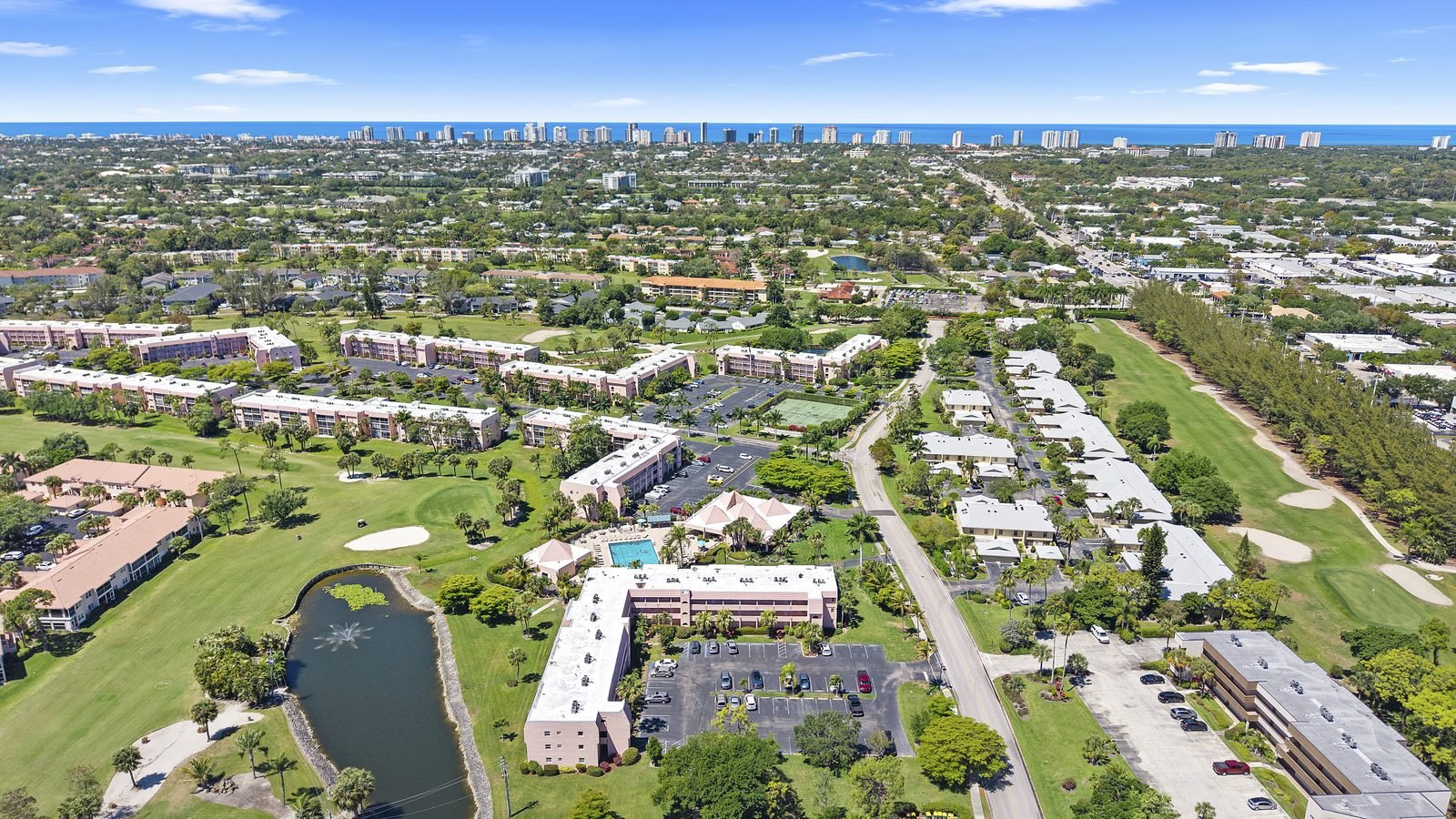 Aerial view over low-rise golf course condos on Forest Lakes Boulevard looking toward the Gulf of Mexico in Naples, Florida
