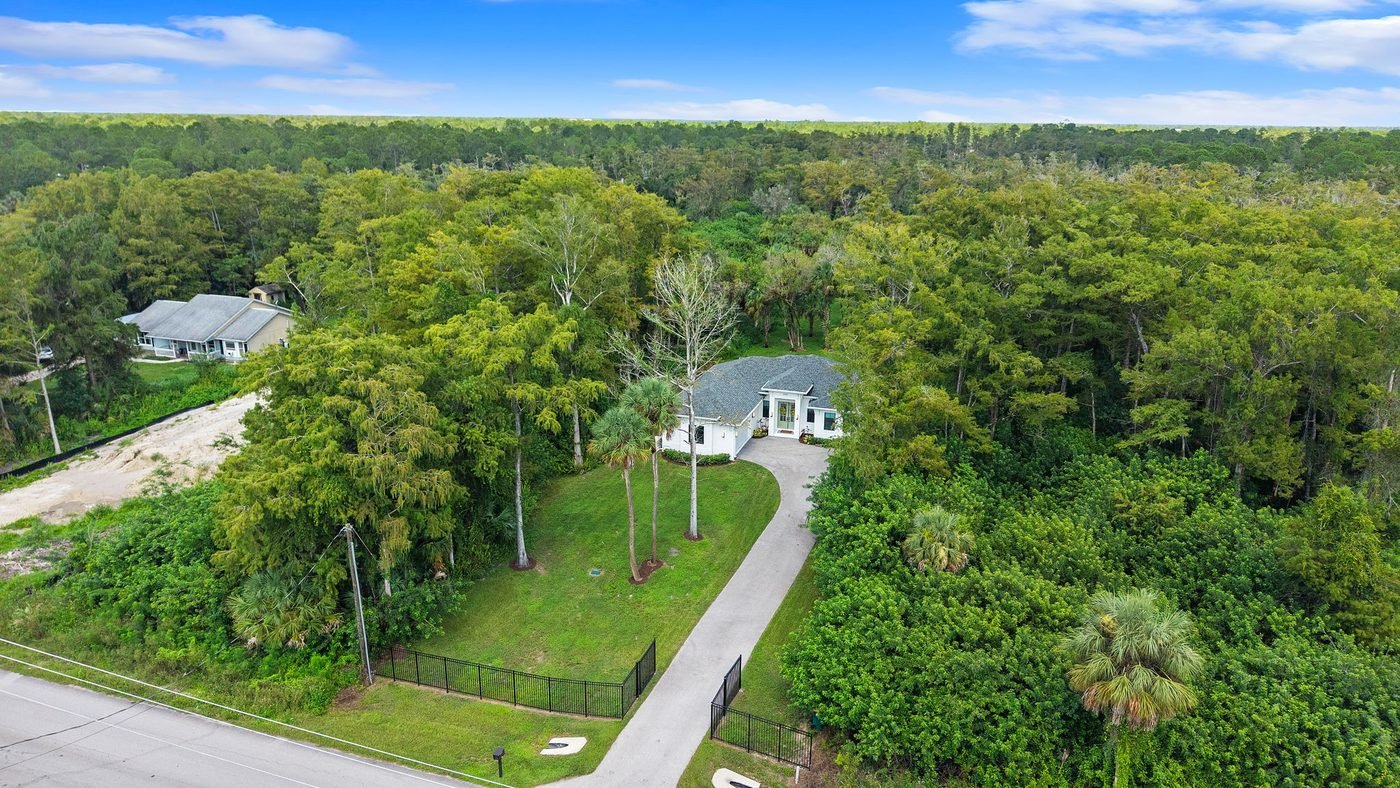 Aerial of a brand-new construction home beside older resale homes in Golden Gate Estates, Naples, Florida