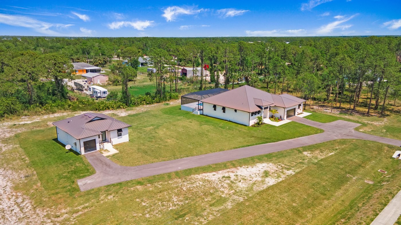 Wide aerial of a Golden Gate Estates acreage home with guest house on well and septic in Naples, Florida