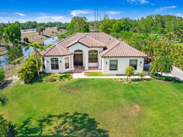 Aerial of a Golden Gate Estates home on nearly 3 acres at 6341 Green Blvd in Naples, Florida, with a wide lawn and tile roof