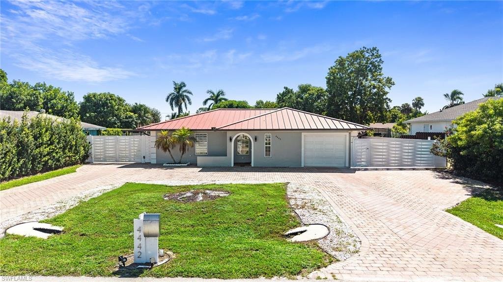 Aerial front view of 4442 18th Ave SW, a metal roof pool home in Golden Gate City, Naples