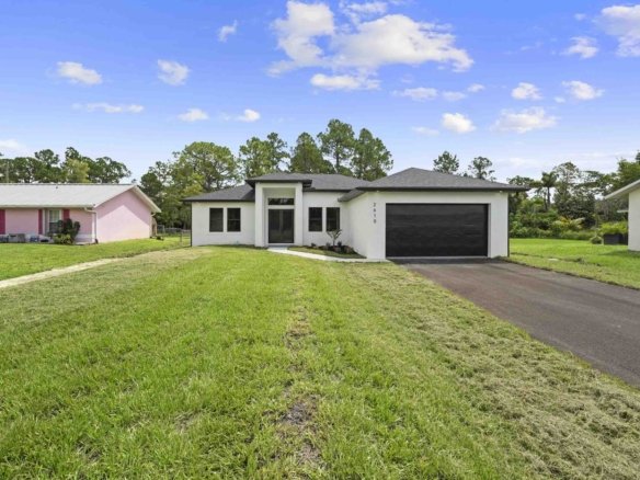 New construction home on a 1.14-acre lot with a long front lawn in Golden Gate Estates, Naples, Florida