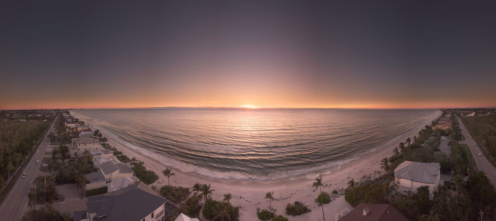 Aerial panorama of the Naples, Florida beach and waterfront homes at golden hour