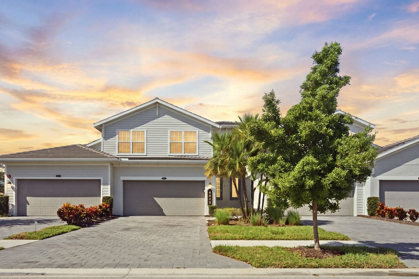 Coach home with a three-car garage at The National Golf and Country Club in Ave Maria near Naples, Florida, at twilight