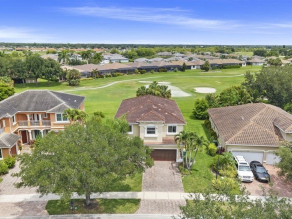 Aerial of a two-story home backing to the golf course at Valencia Country Club in Naples, Florida